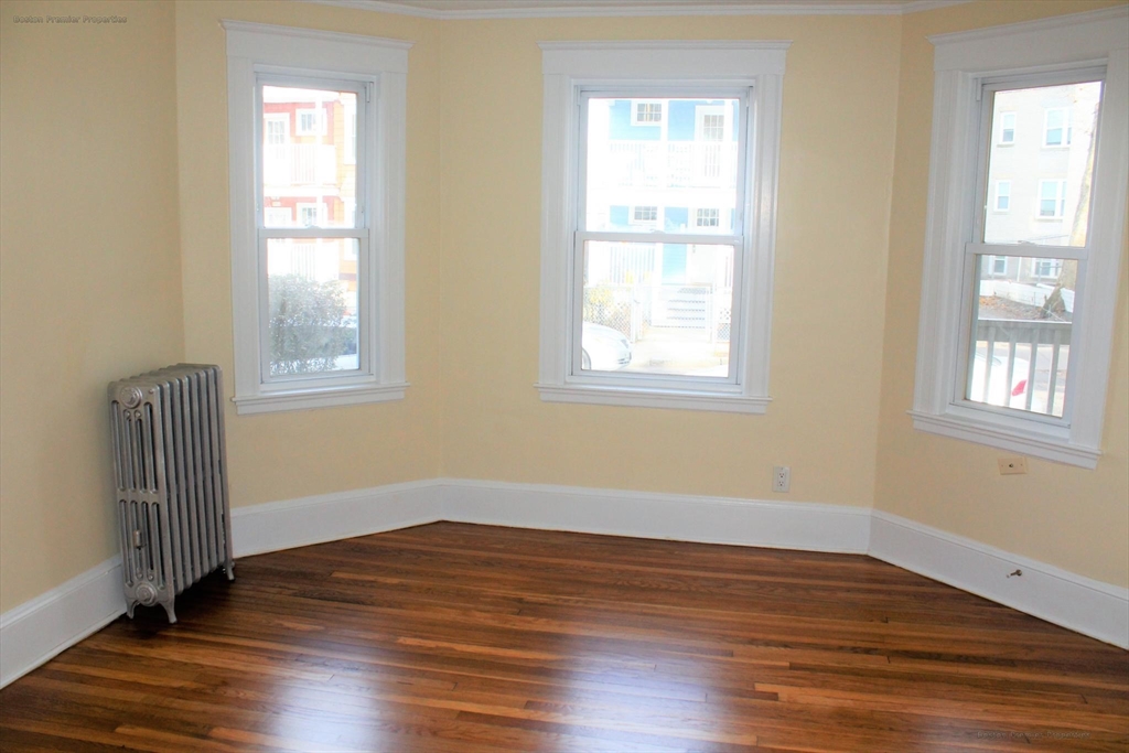 14 Ginita Street, Unit 1 Boston, MA 02122 - Photo 5 of 12 an empty room with wooden floor and windows