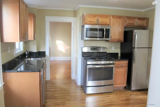 a kitchen with granite countertop a stove and a refrigerator