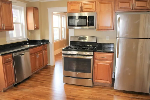 a kitchen with stainless steel appliances granite countertop a stove a refrigerator and a sink