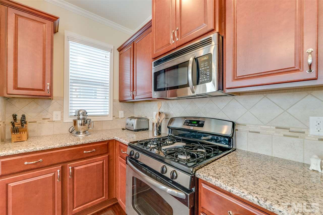 1564 Rodessa Run Raleigh, NC 27607 - Photo 12 of 25 a kitchen with stainless steel appliances granite countertop a sink stove and microwave