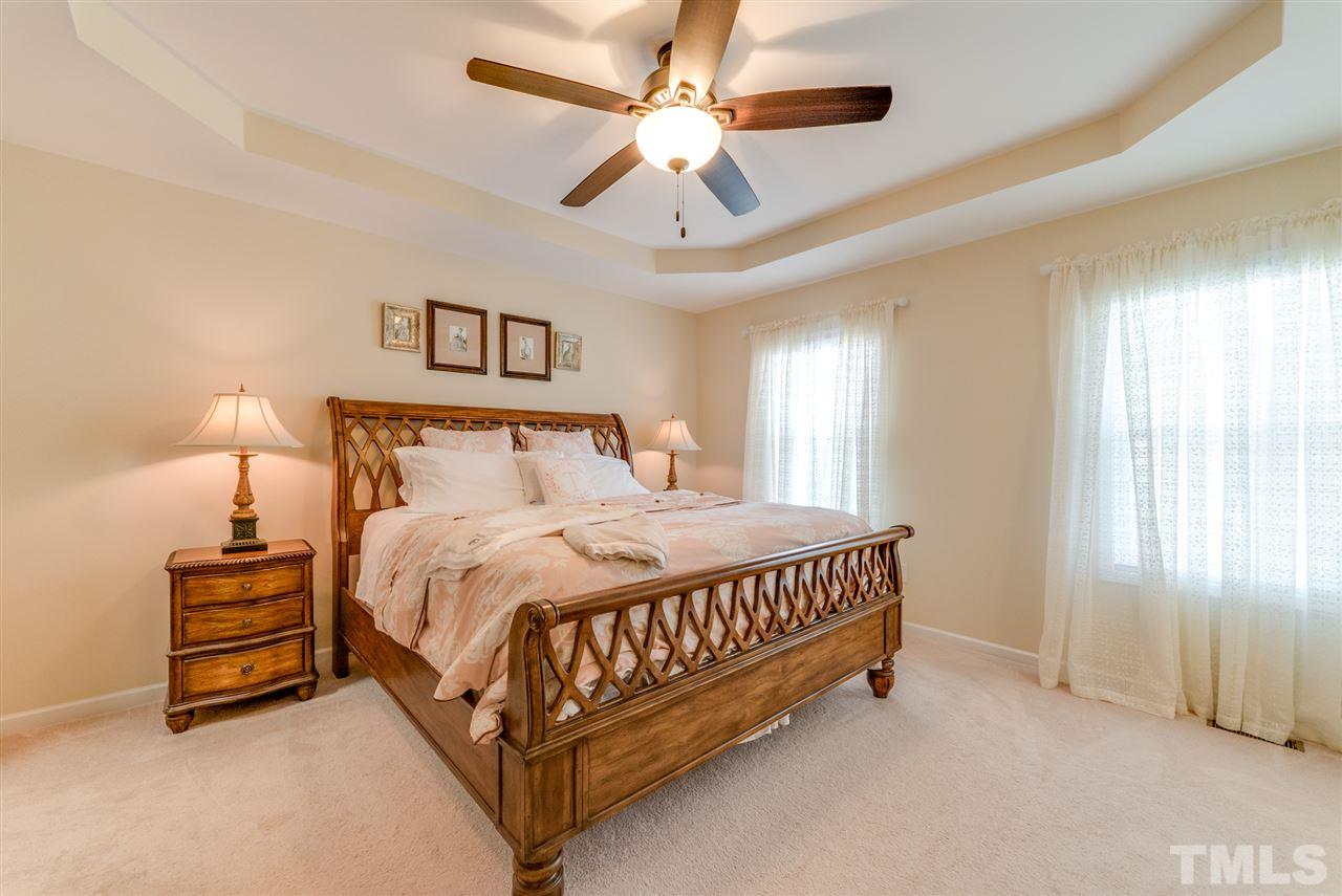 1564 Rodessa Run Raleigh, NC 27607 - Photo 13 of 25 a bed sitting in a spacious bedroom next to a window and a chandelier
