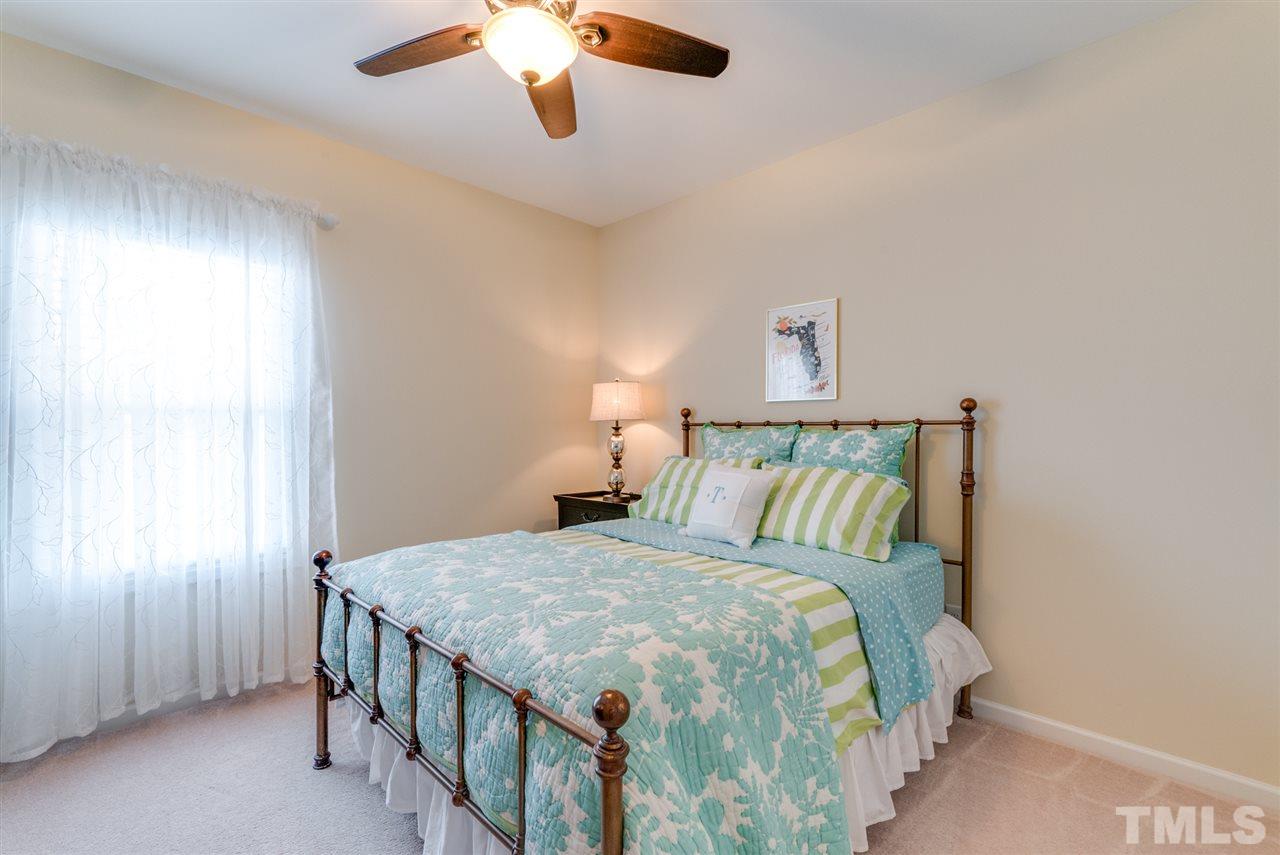 1564 Rodessa Run Raleigh, NC 27607 - Photo 20 of 25 a bedroom with a bed and a chandelier