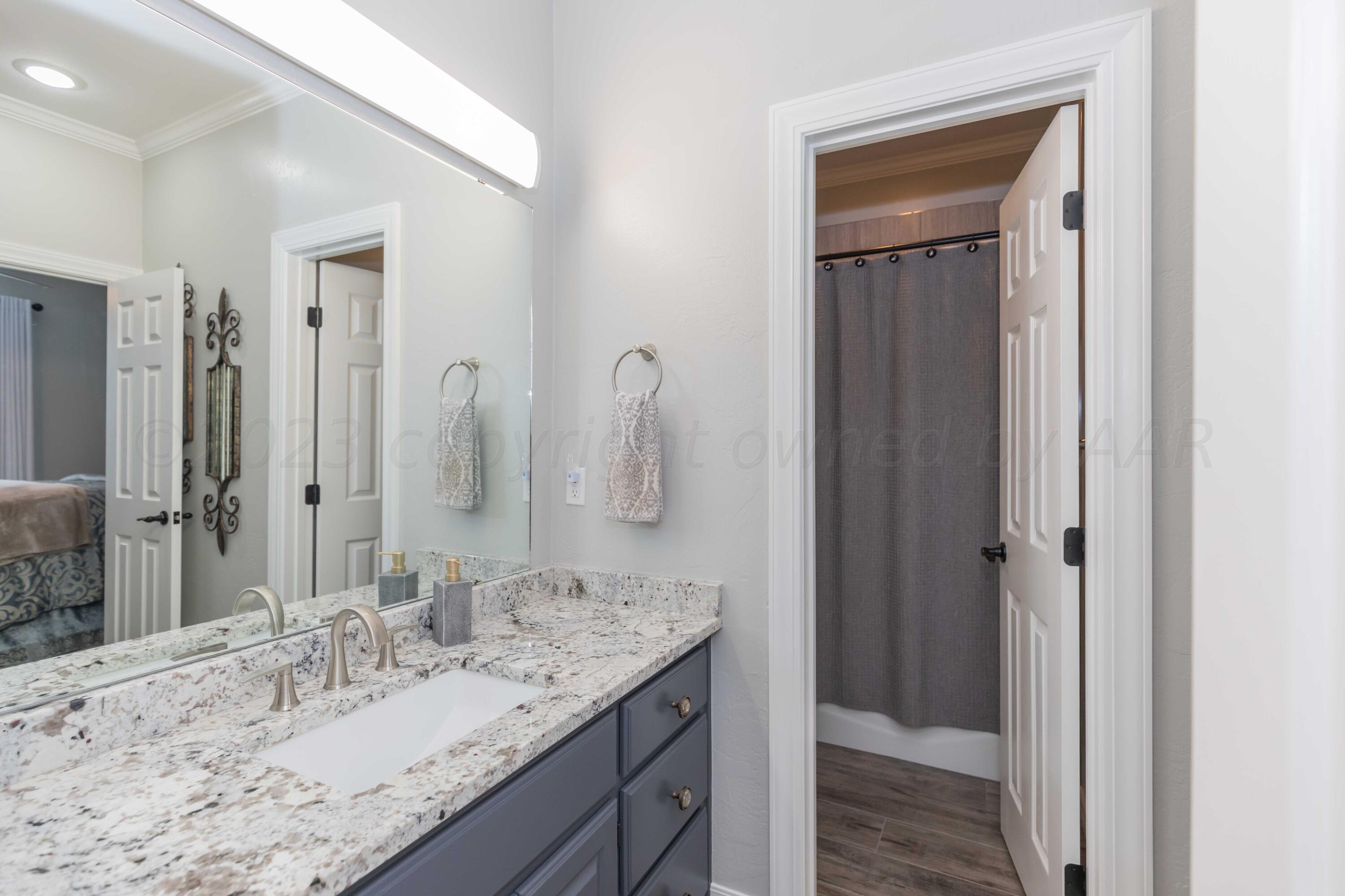 2308 Madera Place Amarillo, TX 79124 - Photo 45 of 61 a bathroom with a granite countertop sink and a mirror