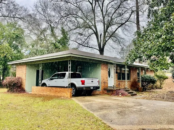 a front view of a house with cars parked