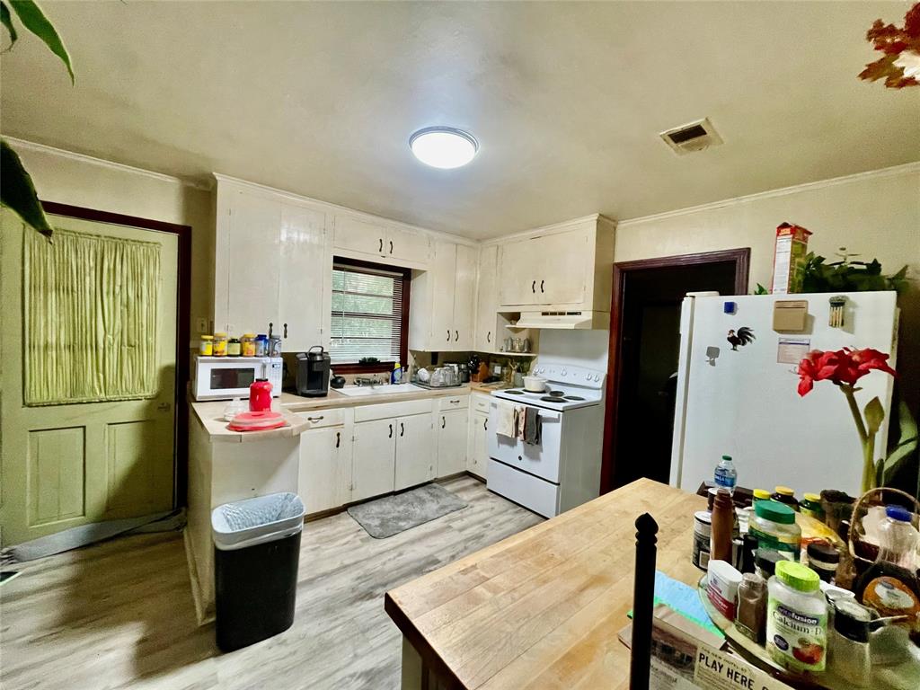 701 Bymo Drive Minden, LA 71055 - Photo 3 of 18 a kitchen with refrigerator and wooden floor
