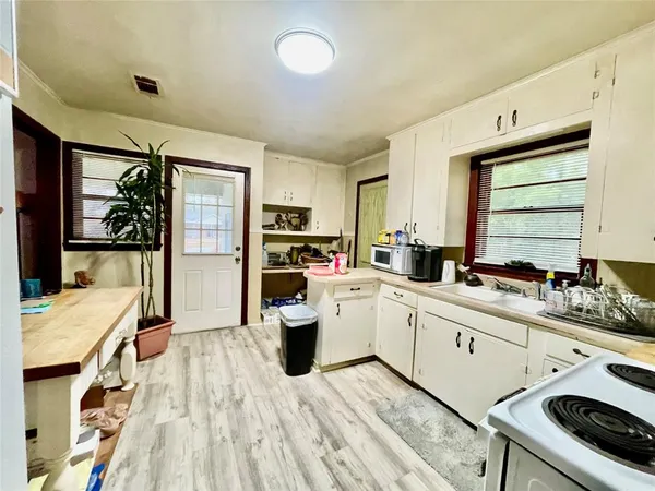 a kitchen that has a lot of cabinets a sink and appliances in it