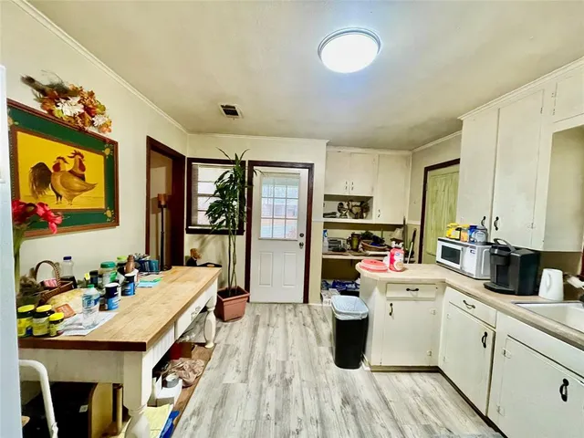 a kitchen that has a lot of cabinets a sink and appliances in it