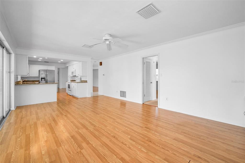 4 Hibiscus Road Belleair, FL 33756 - Photo 32 of 75 a view of empty room with wooden floor and kitchen view