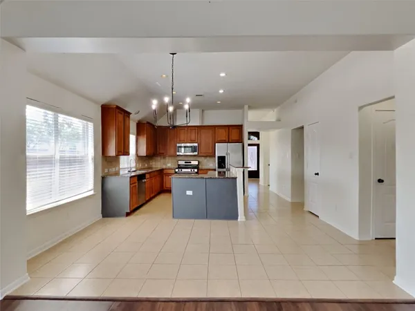 a large white kitchen with a large window cabinets and stainless steel appliances
