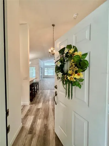 a view of a hallway with wooden floor and a potted plant