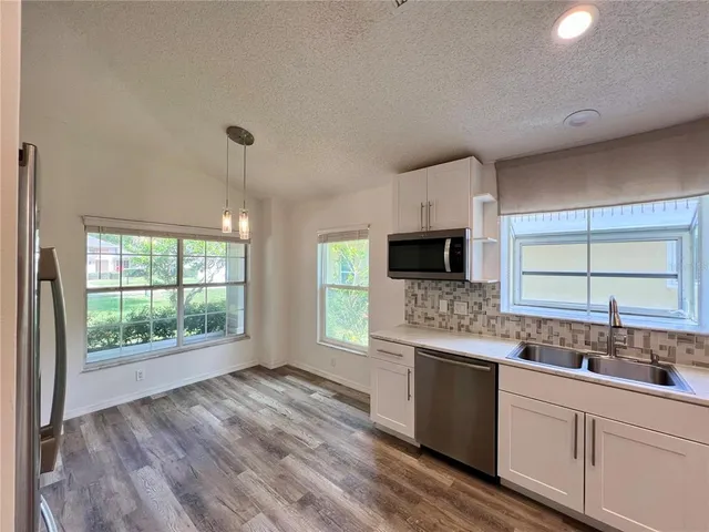 a large kitchen with a large window a sink and stainless steel appliances
