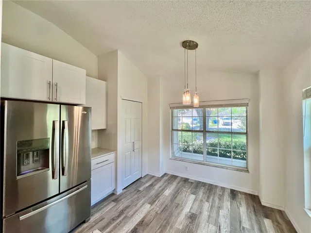 a kitchen with kitchen island wooden floor and a refrigerator