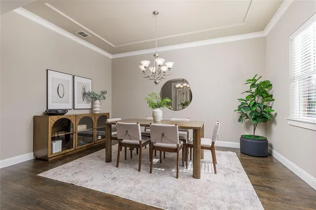 a living room with furniture a dining table a chandelier and a potted plant