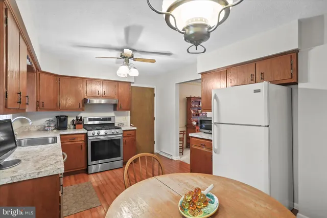 a kitchen with stainless steel appliances granite countertop a refrigerator a stove a sink dishwasher a refrigerator with a dining table and chairs