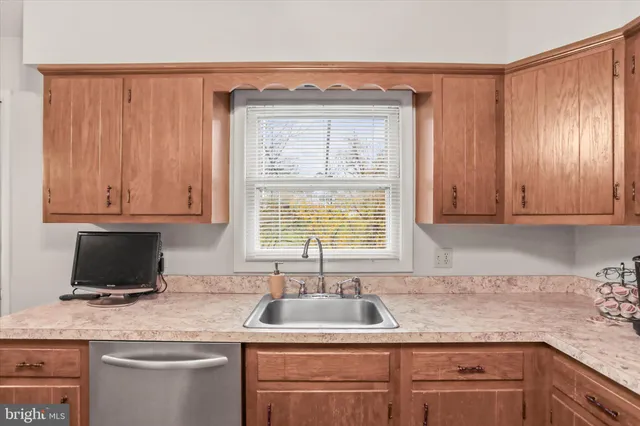 a kitchen with granite countertop a sink window and cabinets