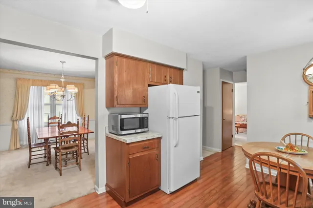 a kitchen with stainless steel appliances a refrigerator a stove a dining table and chairs