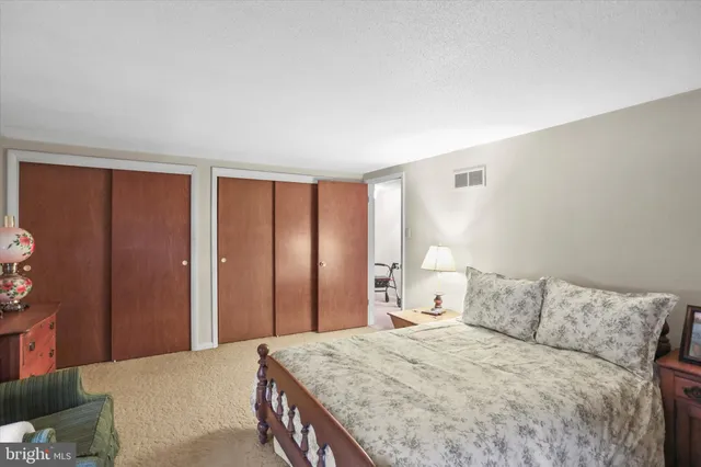 a bedroom with a large bed and wooden floor