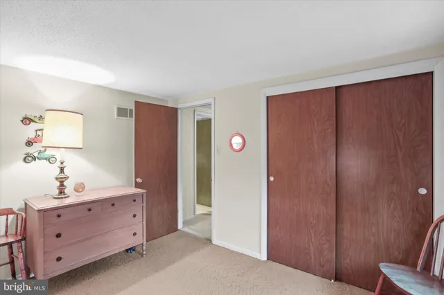 a view of room with cabinet mirror and bedroom view