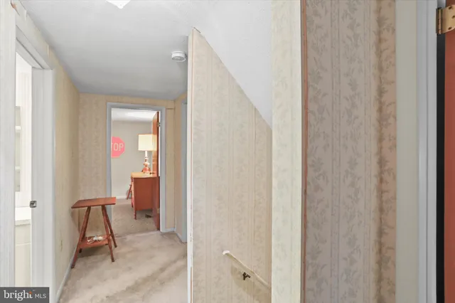 a view of a hallway with furniture and a door