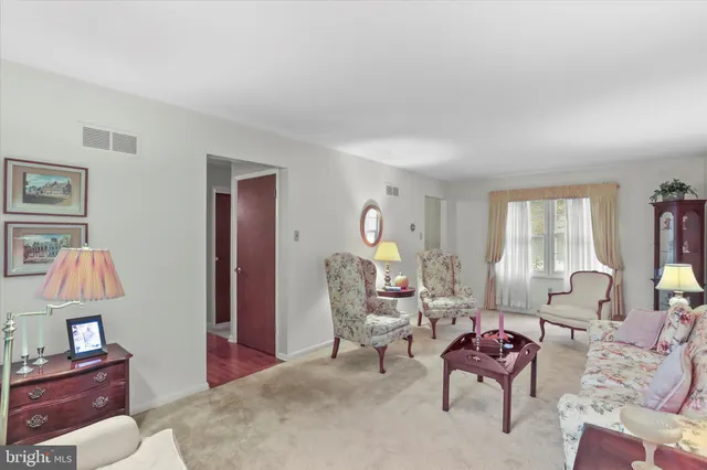 a living room with furniture a window and a lamp