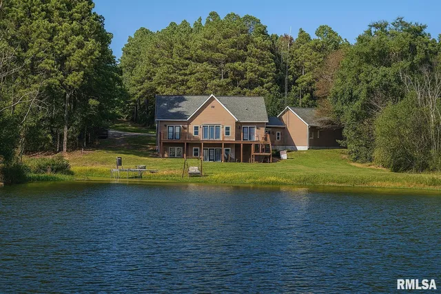 a kitchen with stainless steel appliances kitchen island granite countertop a table chairs sink and cabinets
