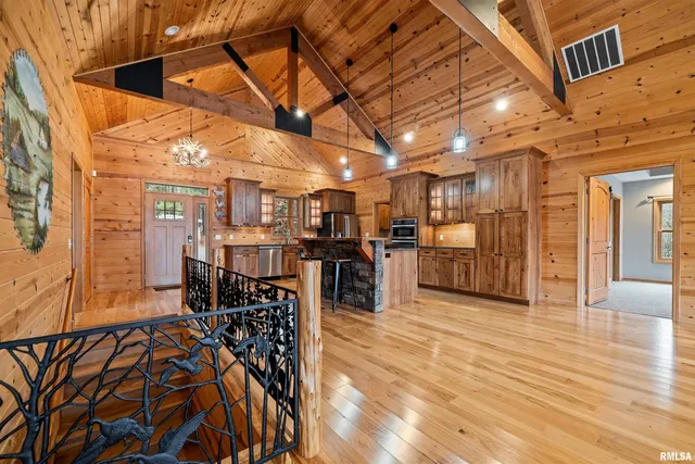 a view of a hall with wooden floor and a fireplace