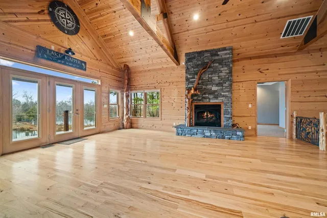 a view of a hall with wooden floor and a fireplace