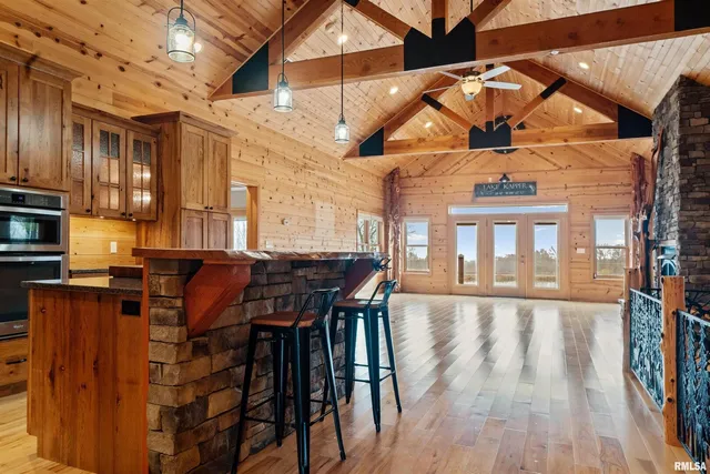 a view of a living room and kitchen with furniture and wooden floor