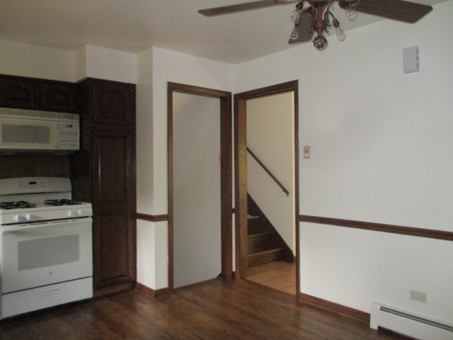 512 Highland Road Hinsdale, IL 60521 - Photo 14 of 25 a kitchen with a refrigerator stove and wooden floor