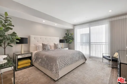 a bedroom with a large bed and a potted plant