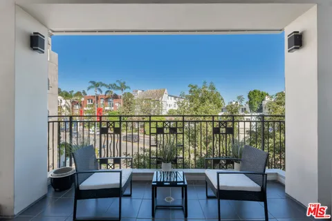 a balcony with wooden floor and outdoor seating