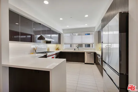 a kitchen with a sink stainless steel appliances a counter top space cabinets and a sink