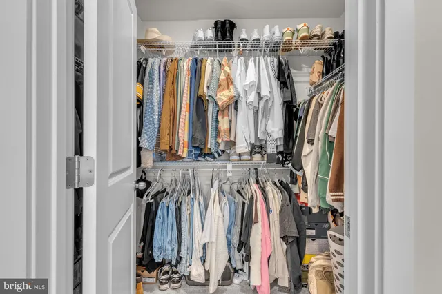 a view of walk in closet with clothes