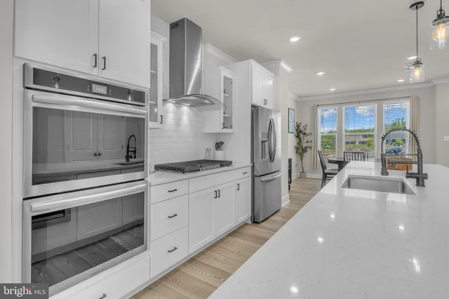 a kitchen with stainless steel appliances a stove sink and refrigerator