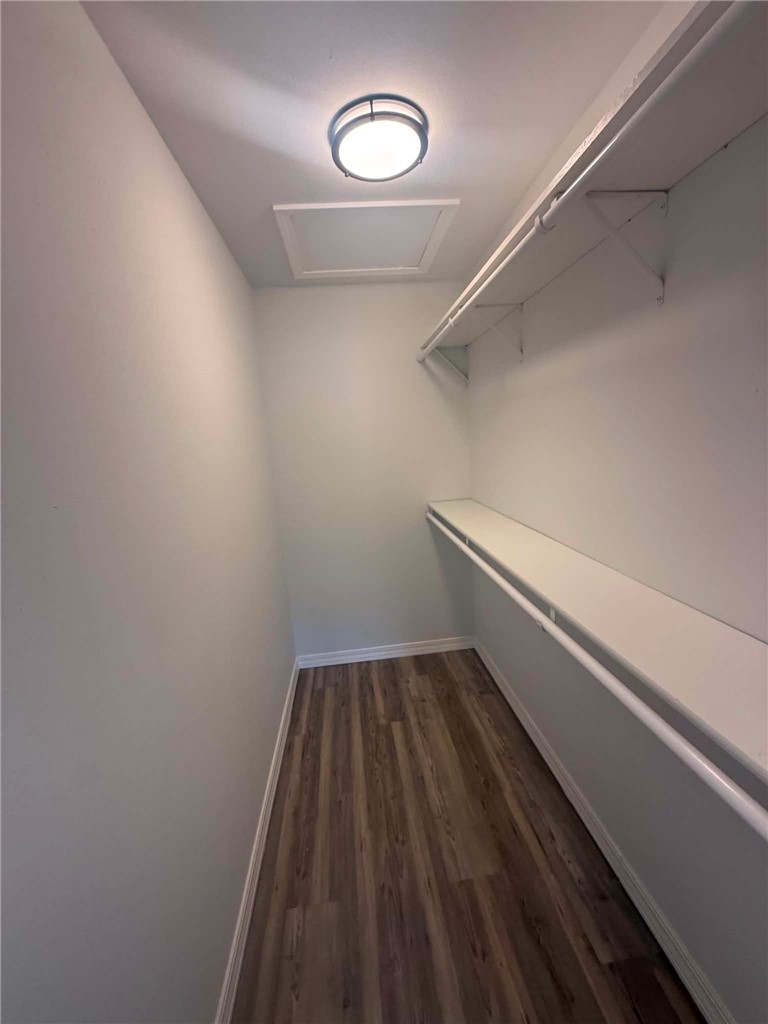 2106 Military Road Dardanelle, AR 72834 - Photo 6 of 16 Wood-finish flooring with white baseboards, overhead flush mount lighting, and built-in shelving with a hanging rod