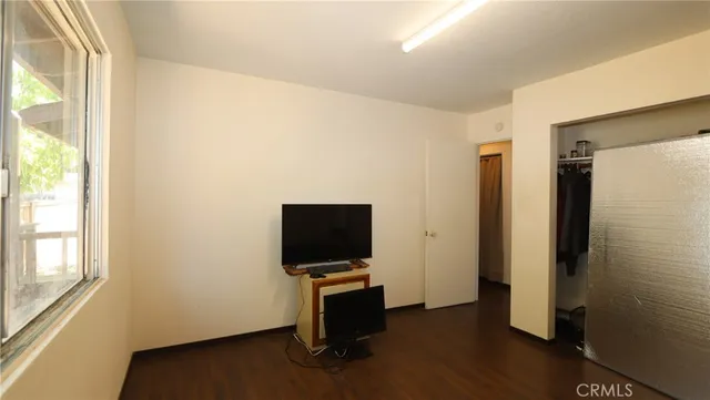 a view of a livingroom with wooden floor and a flat screen tv