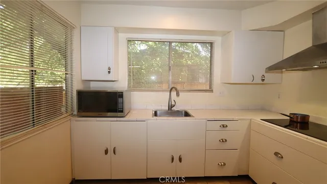 a kitchen with stainless steel appliances white cabinets and a window