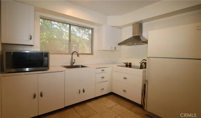 a kitchen with white cabinets and white appliances