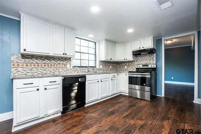 a kitchen with granite countertop white cabinets and white appliances