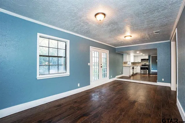 a room with wooden floor and windows