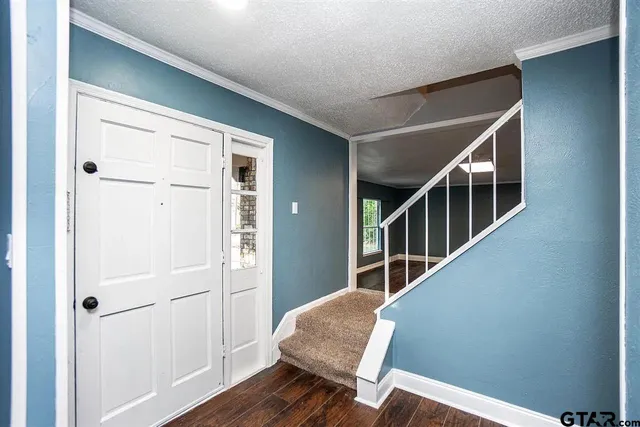 a view of front door with wooden floor and stairs
