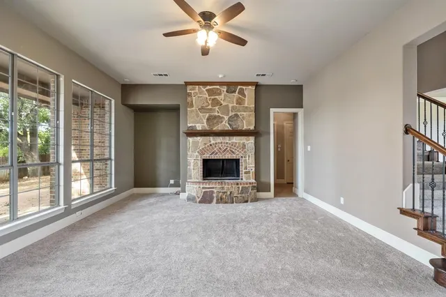 wooden floor fireplace and windows in an empty room