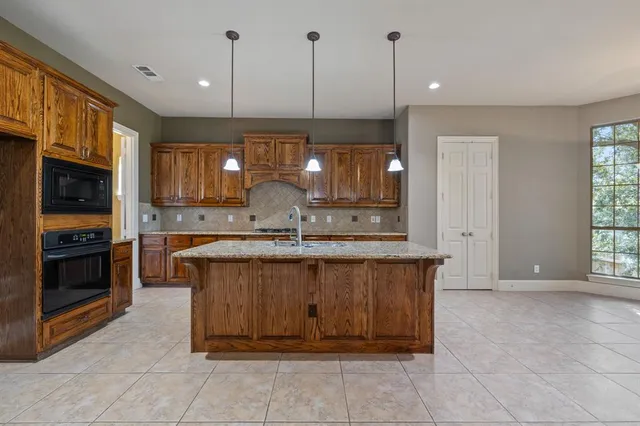 a kitchen with kitchen island a large window a sink and living room view