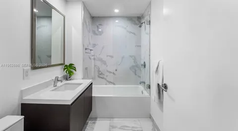 a bathroom with a bathtub a sink and a mirror