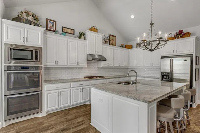 a kitchen with stainless steel appliances granite countertop a sink stove and microwave