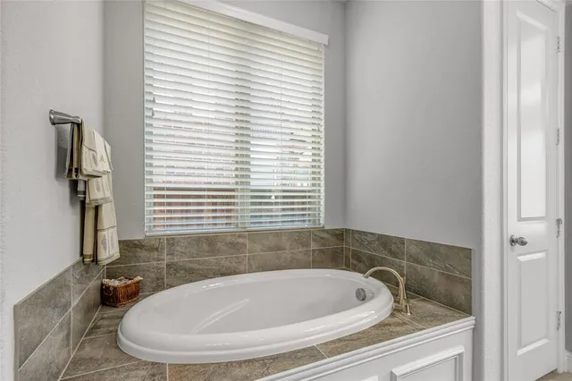 a bathroom with a bathtub and a window