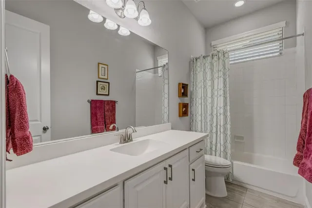 a bathroom with a sink a toilet and a large mirror