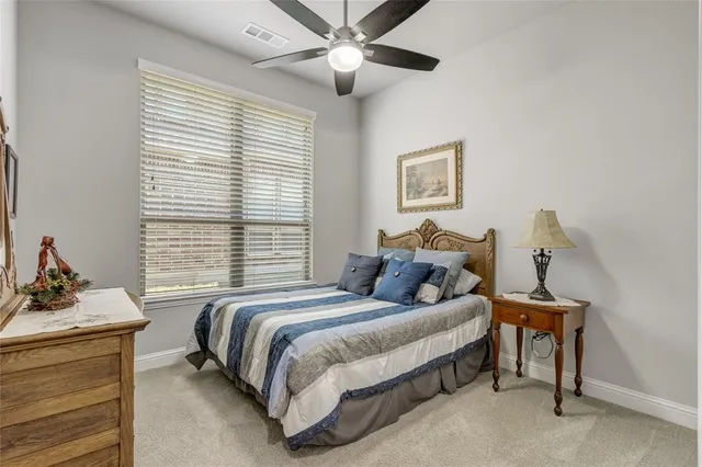 a bedroom with a bed and a dresser with the window