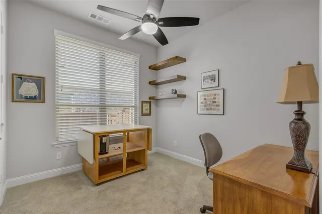 a view of a workspace with furniture and a window