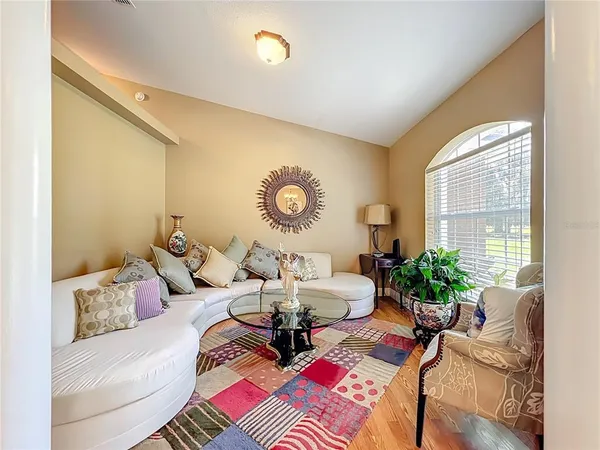 a bedroom with a bed a couch and a flat tv screen on the dresser
